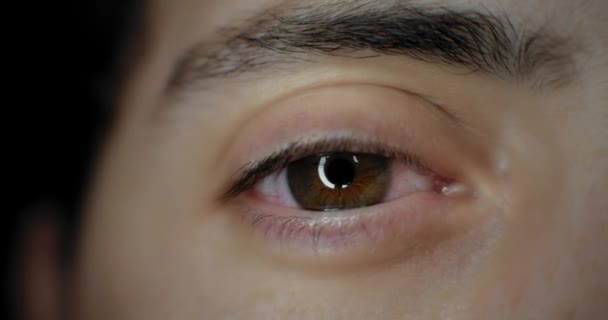 Primer plano de la abertura del ojo marrón de un hombre en una brillante iluminación de estudio. En cámara lenta. BMPCC 4K
 - Imágenes, Vídeo