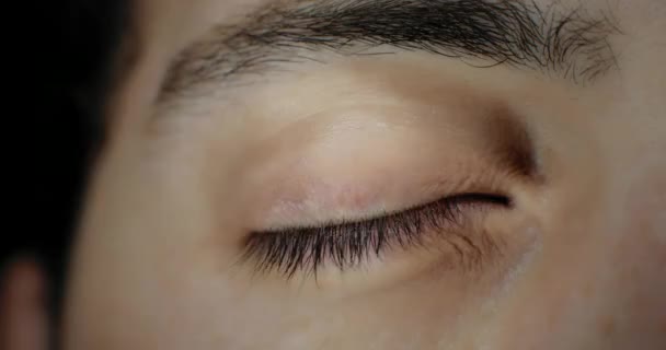 Zbliżenie brązowego oka mężczyzny w jasnym oświetleniu studyjnym. Zwolnij trochę. Bmpcc 4k - Materiał filmowy, wideo