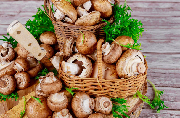 Hnědé portobello houby v proutěném dřevěném košíku s trávou dekorace. - Fotografie, Obrázek