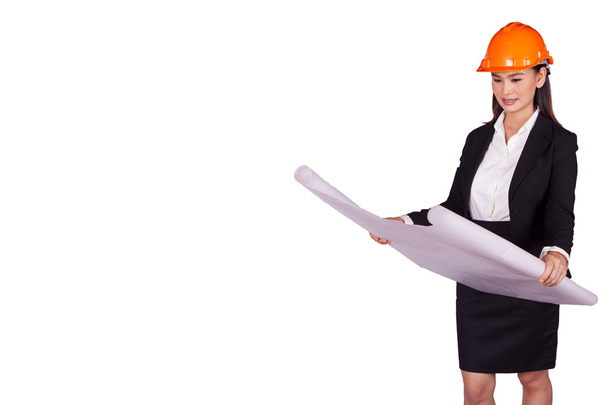 Engenheira mulher em um capacete laranja segurando um plano para o projeto
 - Foto, Imagem