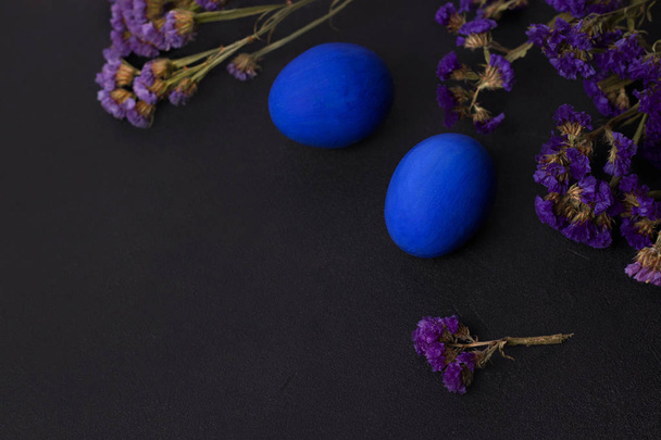 Класичні блакитні великодні яйця на чорному тлі з фіолетовими квітами. копіювання простору
 - Фото, зображення