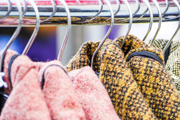 Closeup shot of different clothes hanging in a wardrobe on a blurred background - 写真・画像