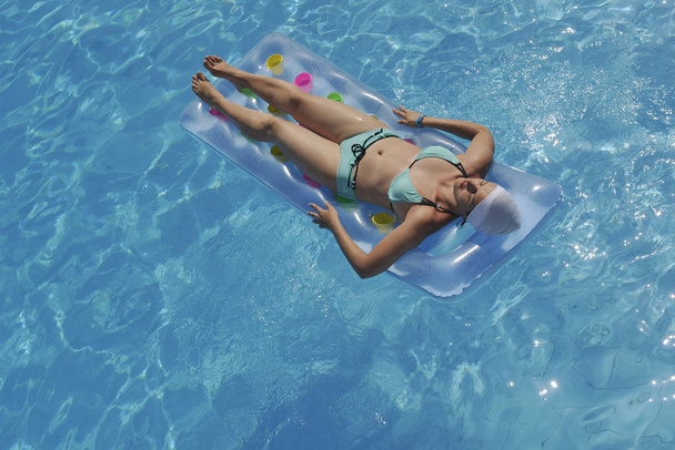 feliz joven mujer relajarse en la piscina en el complejo turístico de vacaciones
  - Foto, imagen