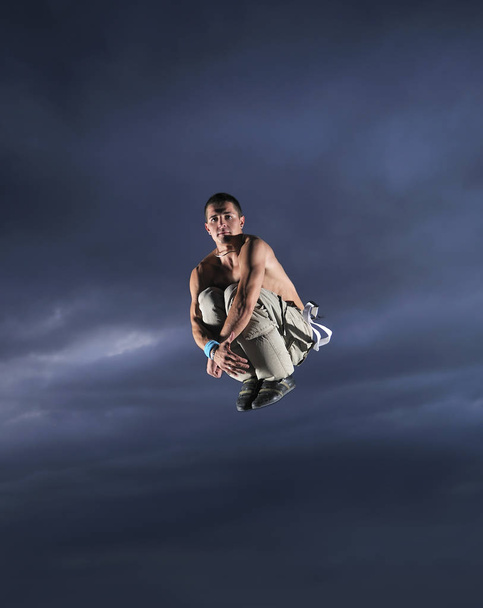 young man dancing and jumping  on top of the building  - 写真・画像