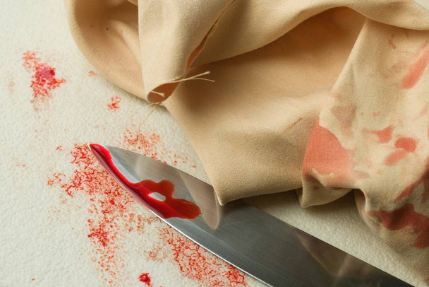A closeup shot of a bloody knife and a wipe on the white background - Foto, Bild
