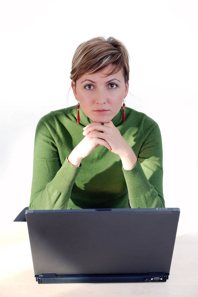 businesswoman in green working on laptop - Фото, изображение