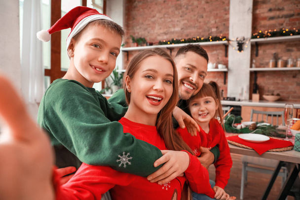 Familia feliz tomando selfie en Nochebuena en la cocina
 - Foto, Imagen