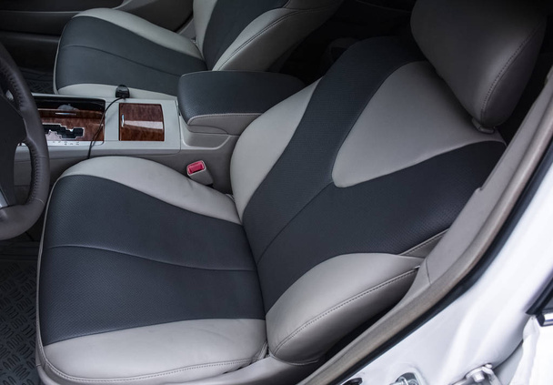 Dos asientos en el interior del coche atados con cuero gris oscuro y gris
 - Foto, imagen
