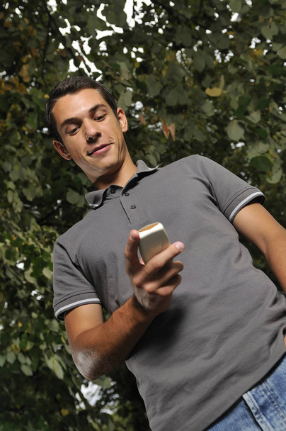 young happy  casual man talking on cellphone and writing sms message - Photo, image