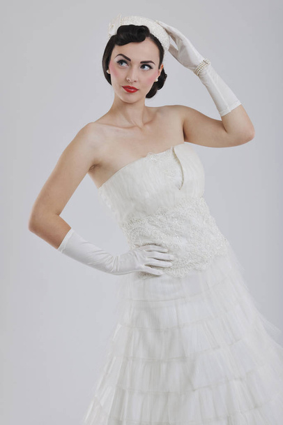 beautiful young bride wearing  wedding dress in retro fashion style isolated on white background in studio - Foto, Imagem