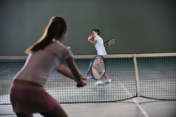 young girls playing tennis game indoori in tennis court - Foto, Imagen