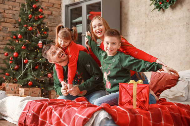 Onnellinen perhe jouluaattona kotona
 - Valokuva, kuva