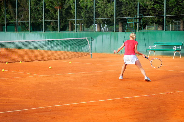 Girl playing tennis outdoor on court - Fotó, kép