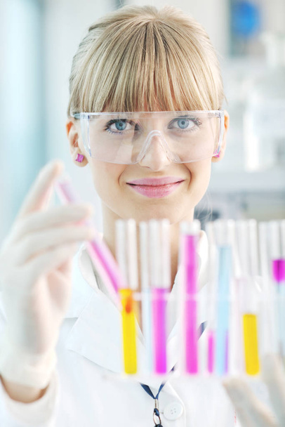 doctor student  female researcher holding up a test tube in chemistry bright labaratory - Foto, Imagem