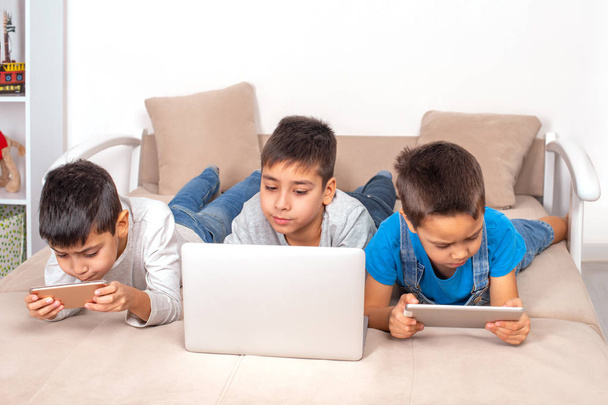 Crianças de diferentes idades usam gadgets para jogos, comunicação
  - Foto, Imagem