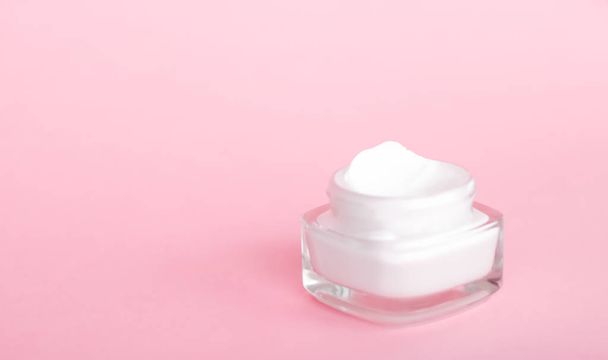 Gezicht crème moisturizer pot op roze achtergrond, hydraterende huid - Foto, afbeelding