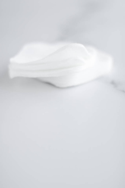 Tampons en coton biologique sur fond de marbre, cosmétiques et maquillage
  - Photo, image
