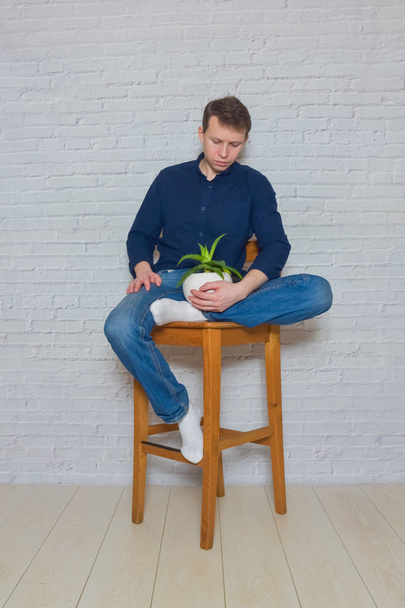 man on a wooden chair with a flower of emotion - Фото, зображення