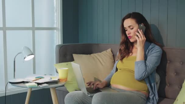 Serious pregnant businesswoman talking mobile phone at home office. - Felvétel, videó