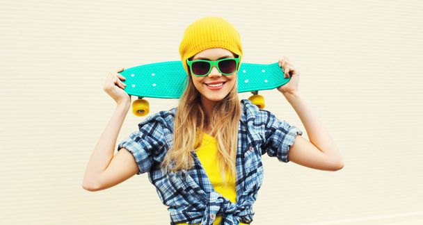 Portrait cool smiling woman with skateboard wearing colorful yel - Foto, Imagem