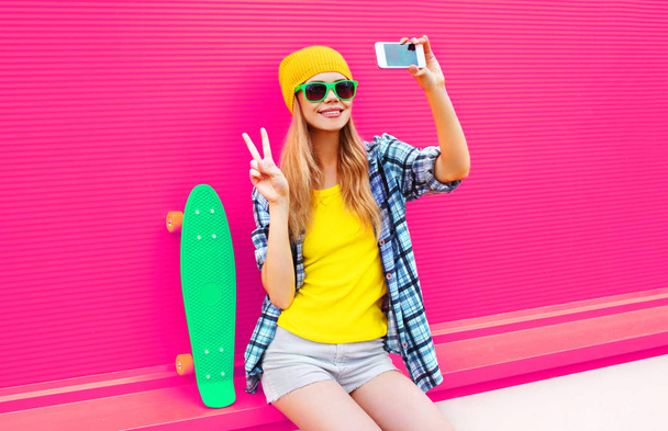 cool smiling woman taking selfie picture by smartphone with skat - Foto, afbeelding
