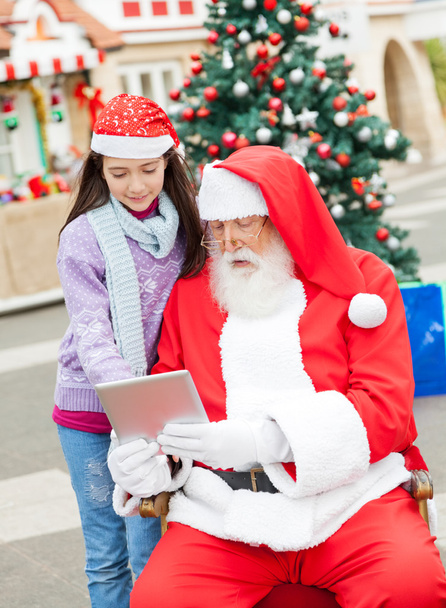 Santa Claus And Girl Using Digital Tablet - 写真・画像
