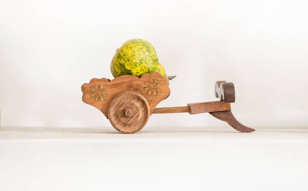 Модель небольшой деревянной повозки. Деревянный трейлер содержит плод айвы желто-зеленого цвета. от является белым фоном
. - Фото, изображение