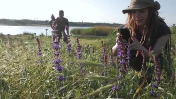 夏の晴れた日に川の近くを旅行するバックパッカーのカップル - 映像、動画