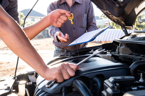 Repairman and insurance agent Checking engine order using modern tools - Photo, Image