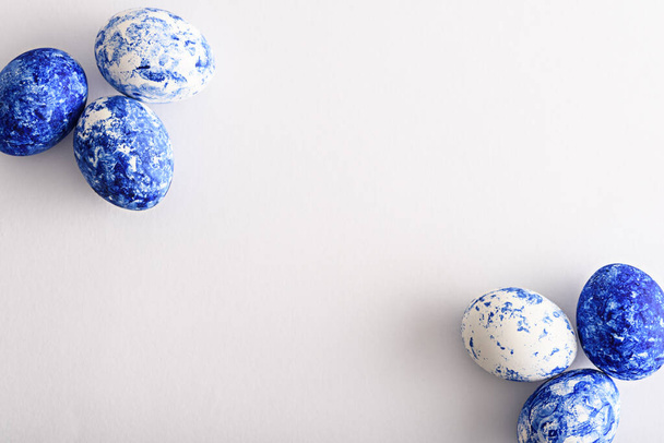 Πασχαλινά αυγά στο χρώμα του έτους-κλασικό μπλε στις γωνίες σε λευκό φόντο - Φωτογραφία, εικόνα