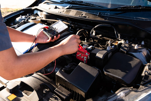 De handen van de reparateur controleren de volgorde van de motor met behulp van moderne gereedschappen - Foto, afbeelding