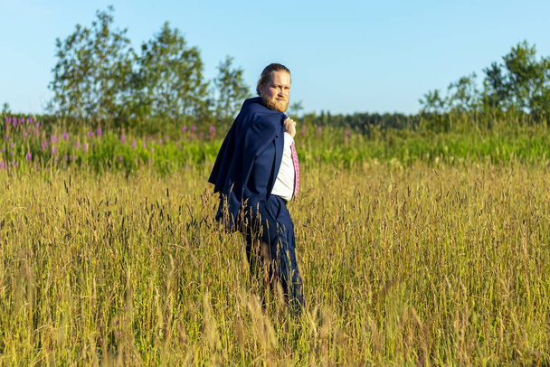 スーツ姿の白人男性が畑を歩いている。自然界の概念事業家 - 写真・画像