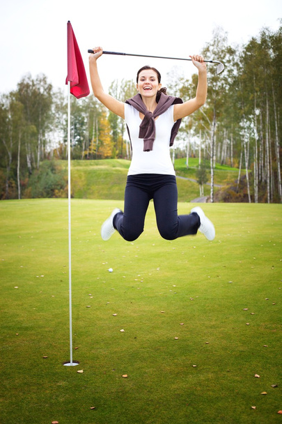 Overjoyed and smiling woman golf player in winner pose - Foto, afbeelding