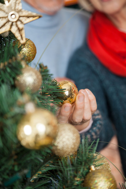 Couple Selecting Baubles Hanging On Christmas Tree At Store - Foto, Imagem