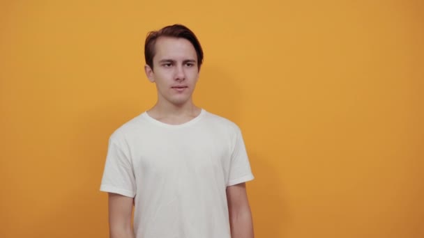 beautiful man on yellow background showing fingers to side. - Záběry, video