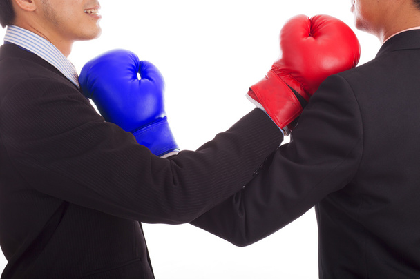 Two businessmen in red and blue boxing glove blocking each other - Valokuva, kuva