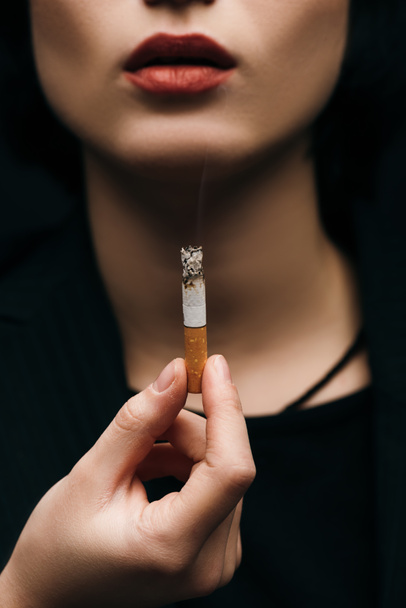 A cigarettát tartó fiatal nő szelektív fókusza  - Fotó, kép