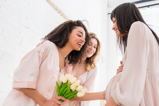 young pregnant woman with multiethnic girlfriends and tulip flowers on baby shower  - Zdjęcie, obraz