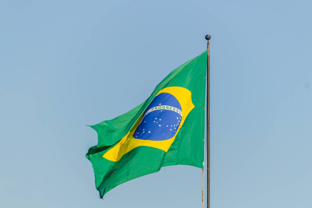 Bandeira brasileira voando com fundo azul céu
 - Foto, Imagem