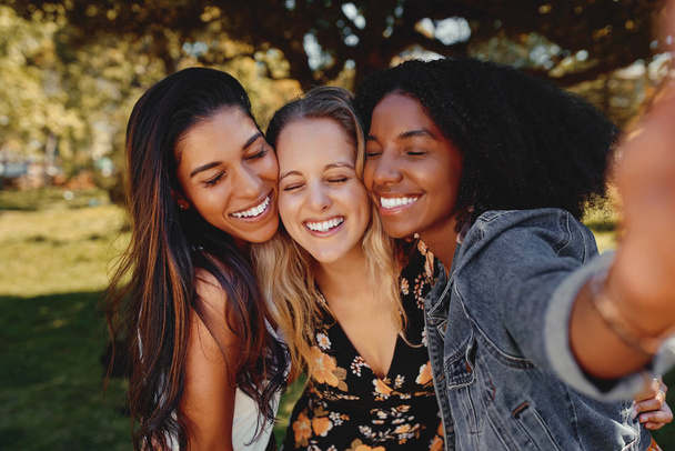 Close up portrait of smiling multiracial millennial women laugh stand posing for group picture together - Group of friends taking a selfie outdoors in the park on a sunny day - Foto, imagen