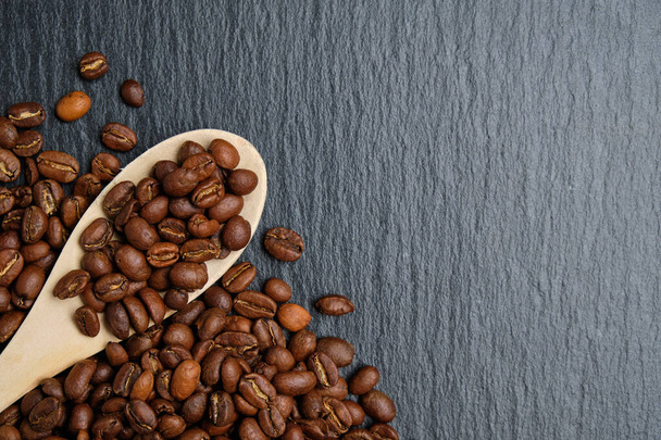 Egy fakanál kávébabbal a palatáblán. Másold a helyet. Felülnézet. - Fotó, kép
