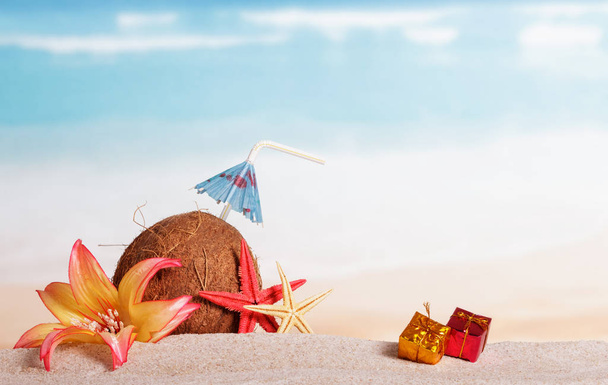 Coconut with drinking straw and umbrella, gifts, starfish  - Foto, Bild