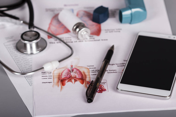 Medical stethoscope, pen, smartphone, inhaler and cartridge - Foto, afbeelding