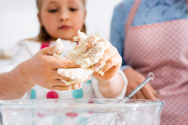Selective focus of child hands in dough above bowl - Photo, Image