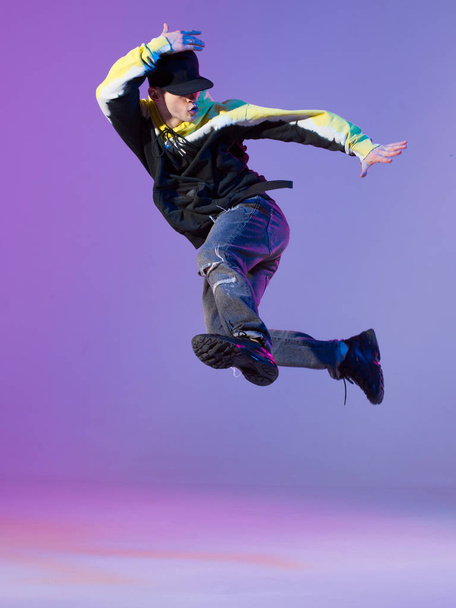 Breakdancing young man in hoodie and baseball cap. Dance school poster. Copy space. Battle competition announcement. - Foto, afbeelding