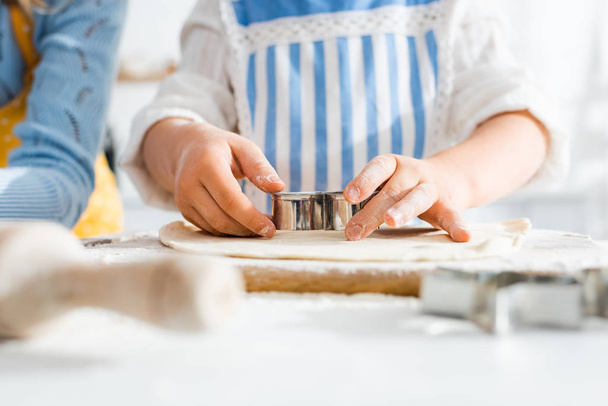 enfoque selectivo del niño usando molde de masa en la masa en la cocina
  - Foto, Imagen