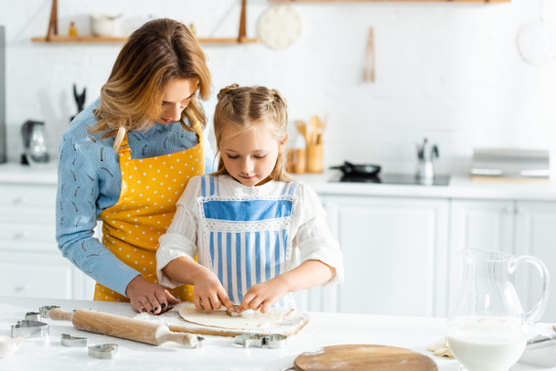 äiti ja tytär ruoanlaitto taikina multaa keittiössä
  - Valokuva, kuva