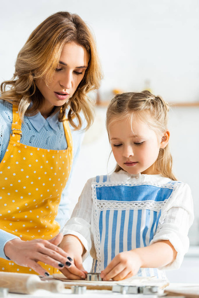 mother and daughter cooking with dough mold in kitchen  - Zdjęcie, obraz