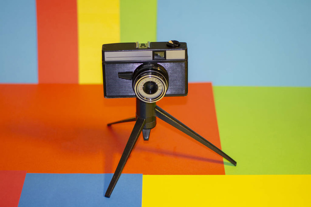 Front view of tripod camera on multicolor background - Zdjęcie, obraz