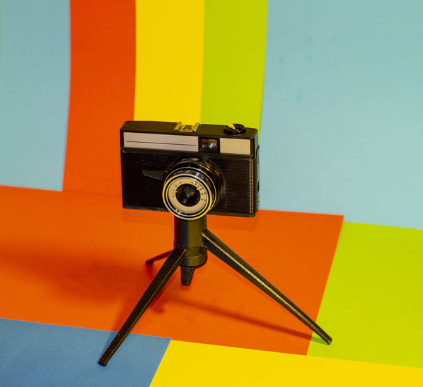 vista della fotocamera treppiede su sfondo multicolore
 - Foto, immagini